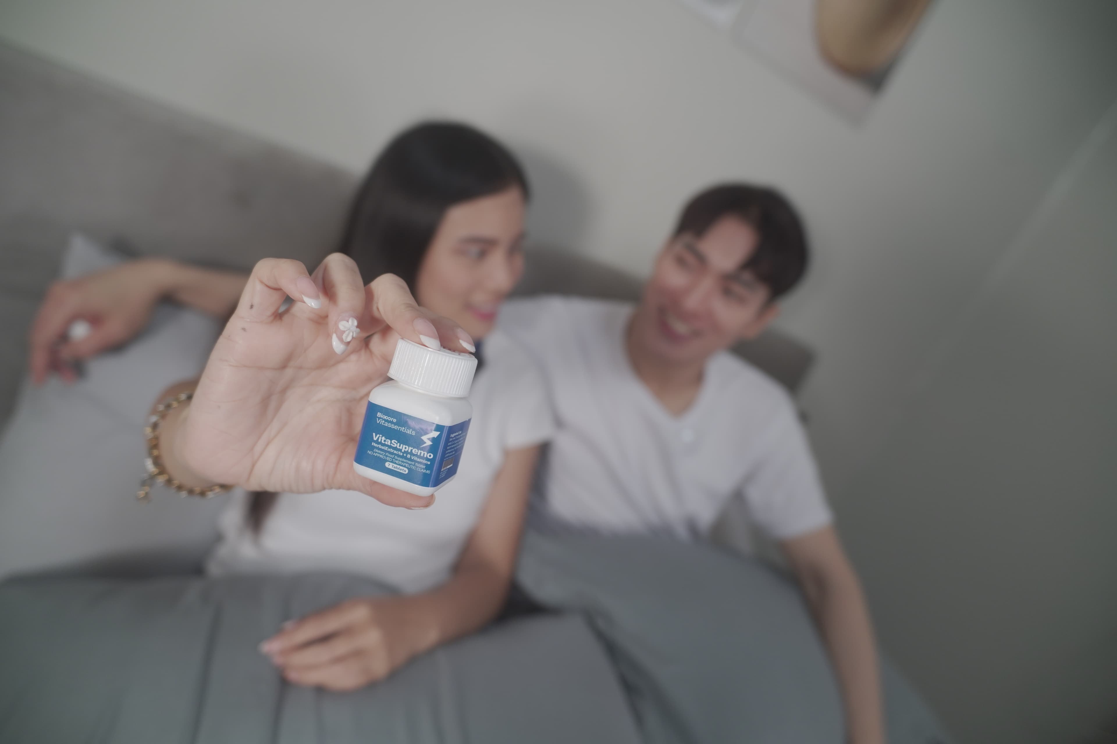 Partner holding VitaSupremo bottle in bedroom morning routine