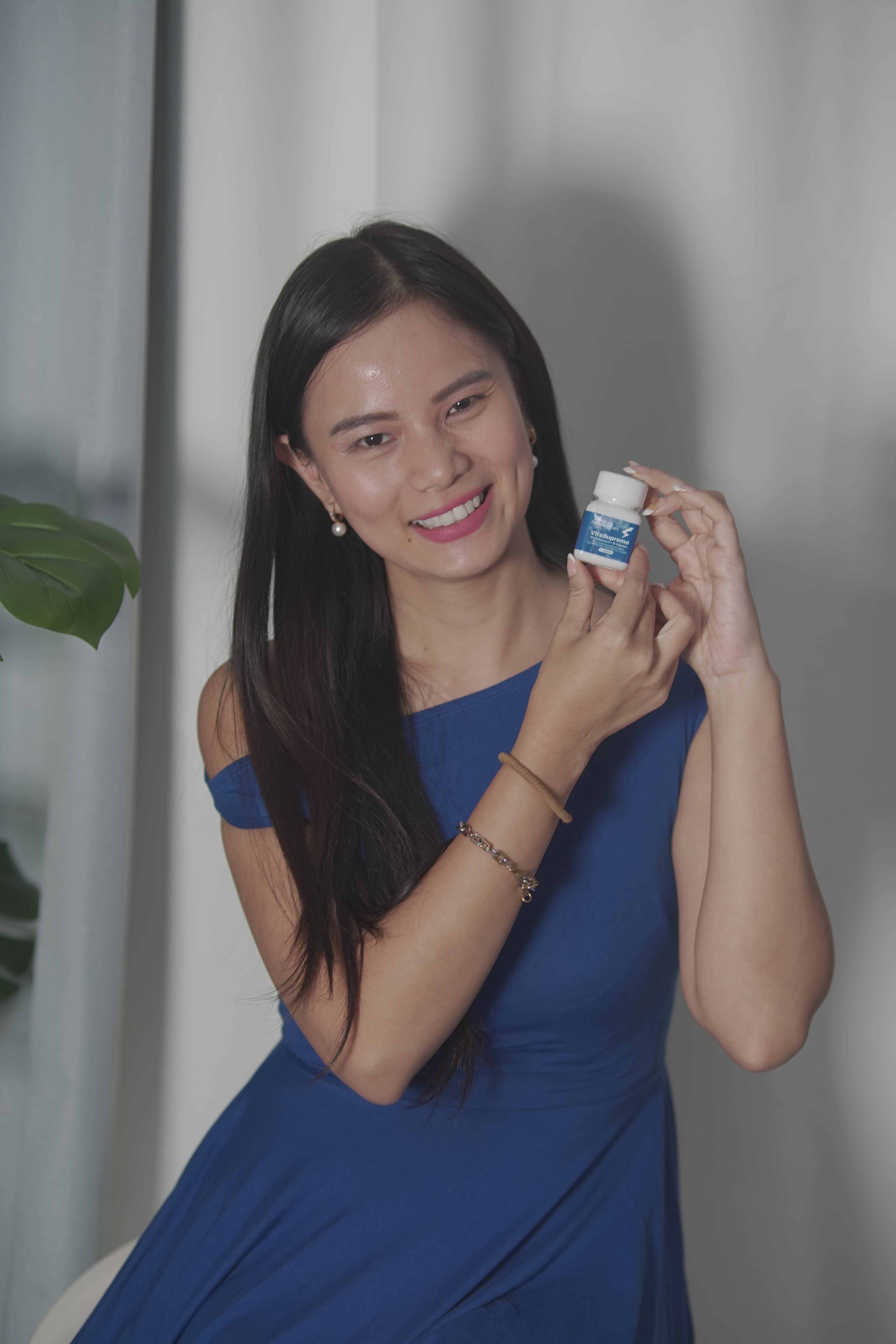 Verified partner holding VitaSupremo bottle with radiant smile