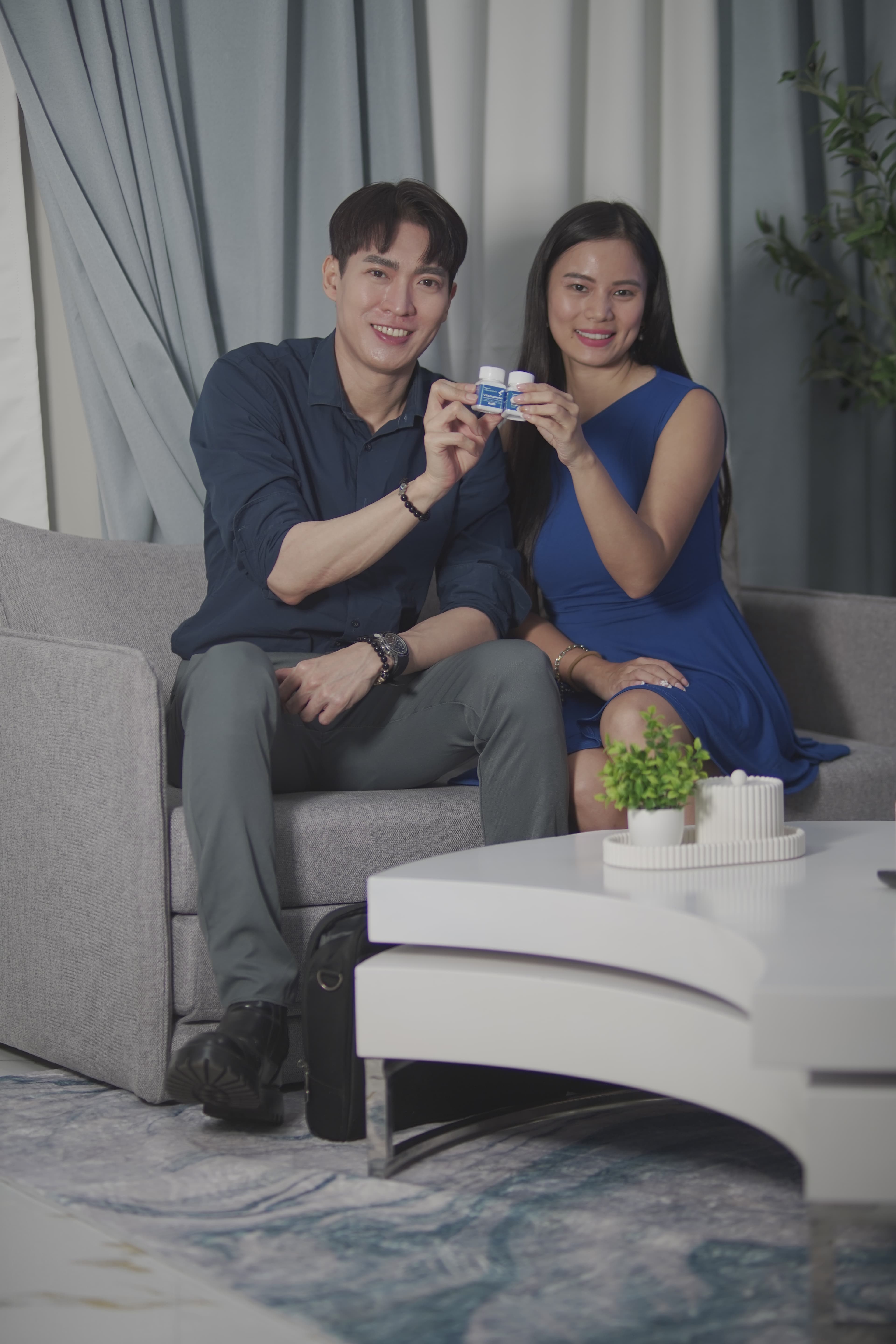 Couple presenting VitaSupremo bottles together to camera