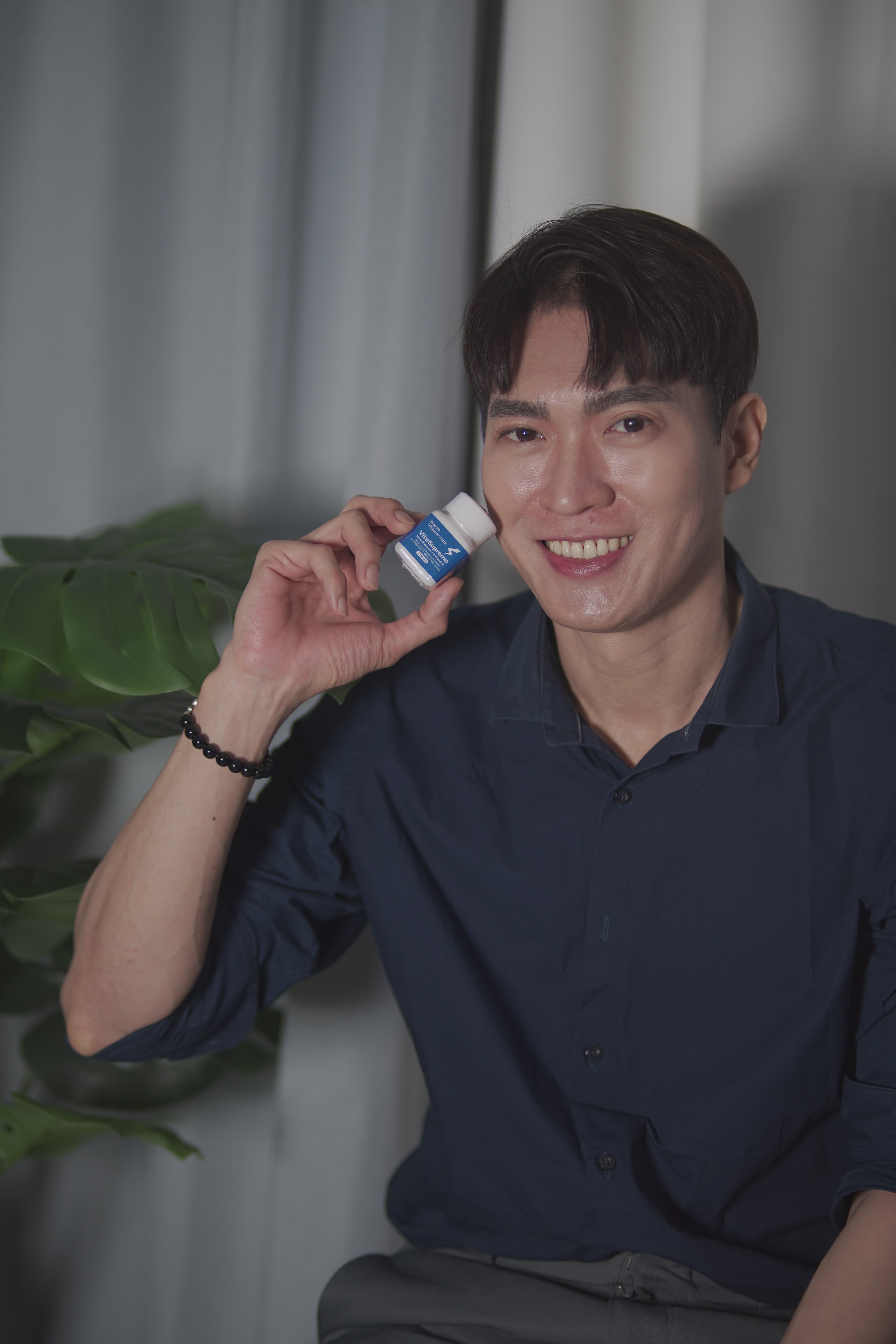 Confident customer smiling warmly with VitaSupremo bottle