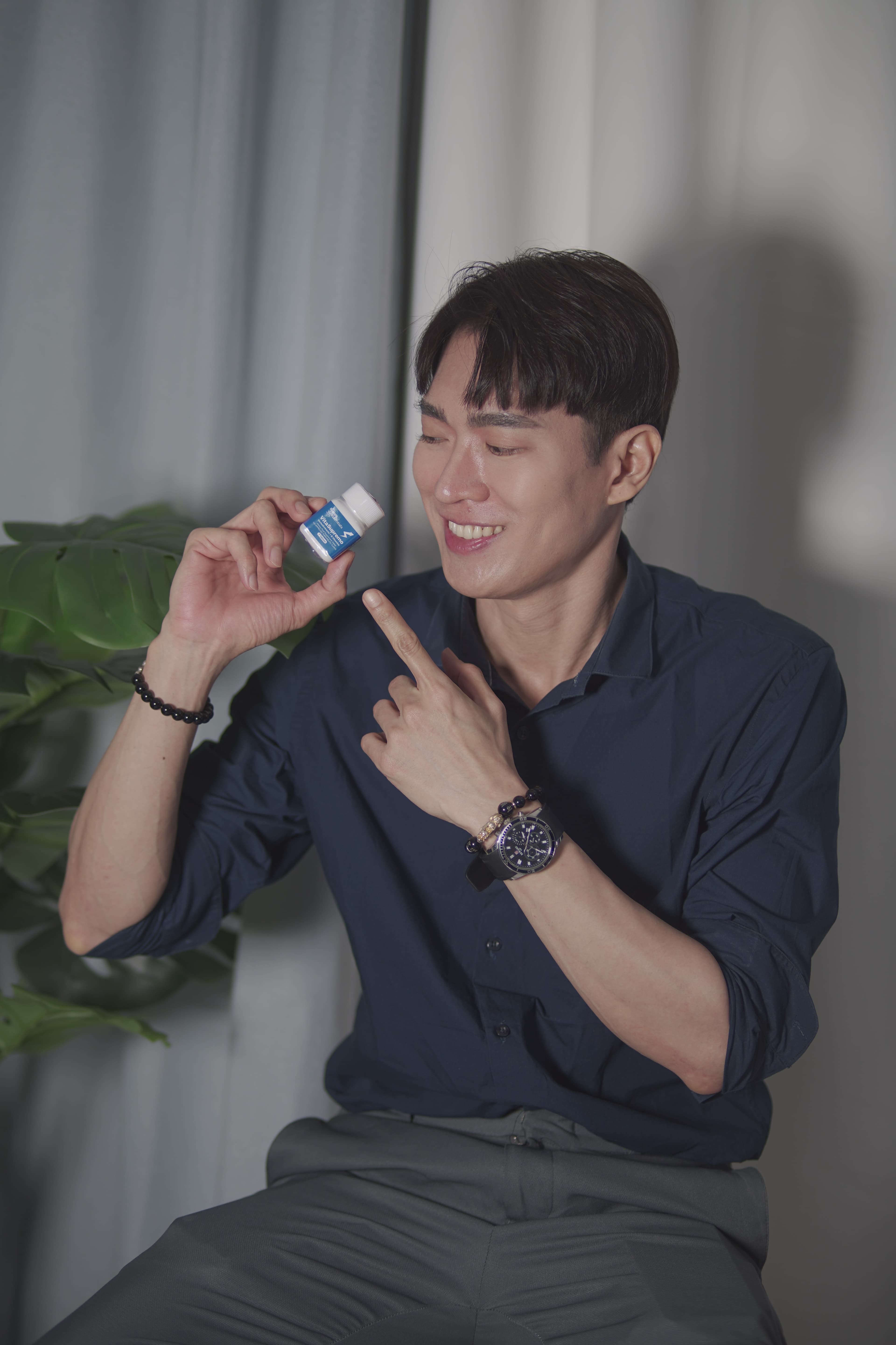 Active man pointing to VitaSupremo supplement bottle