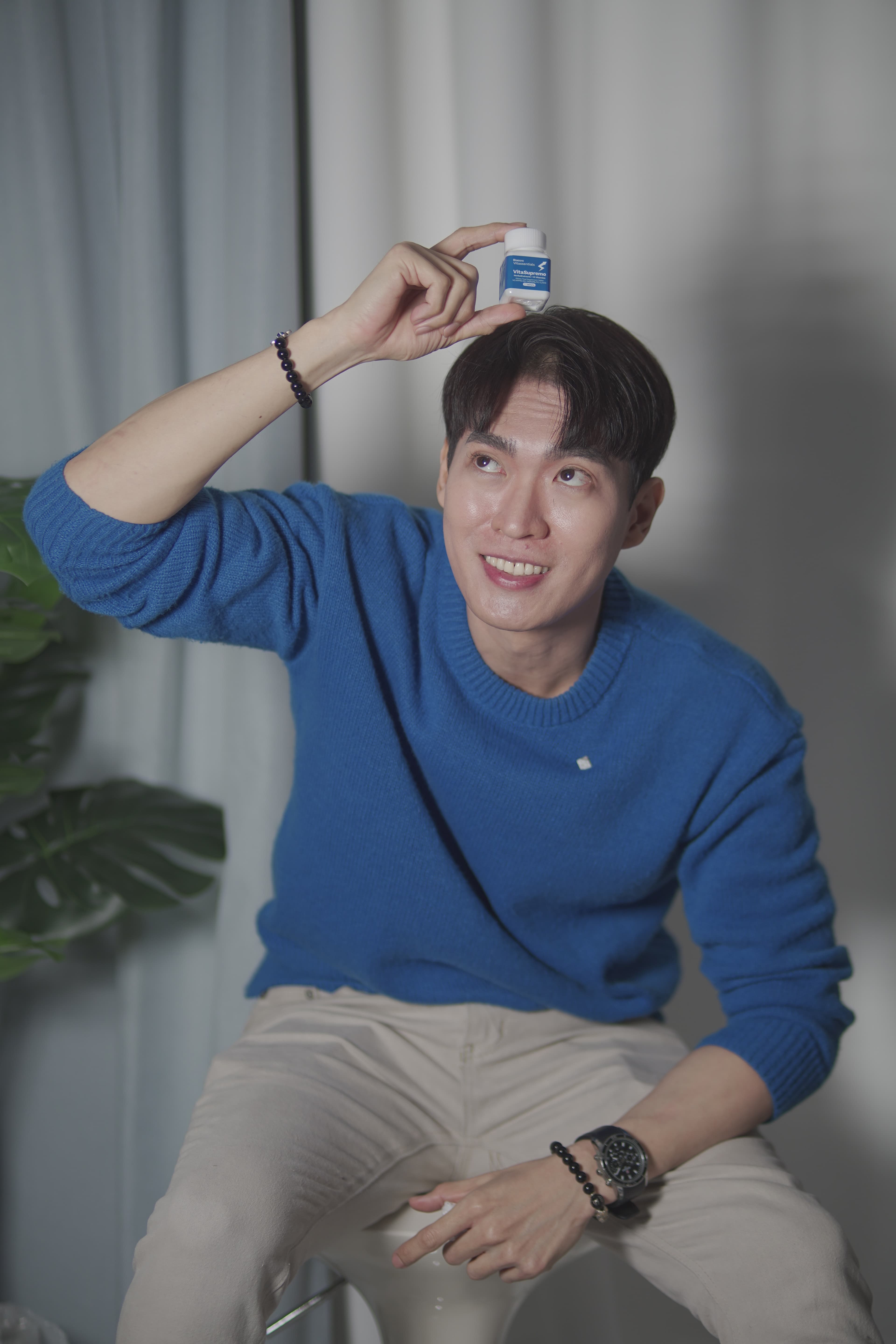 Customer playfully showcasing VitaSupremo bottle with joyful smile